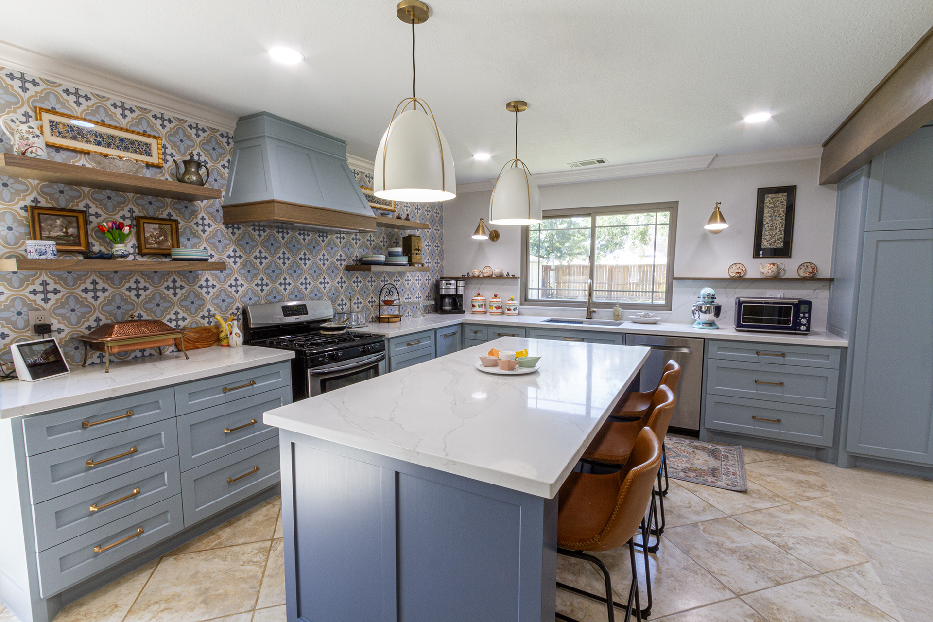 Kitchen with grey-blue cabinetry, patterned tile splashback, marble island and open timber shelving