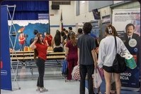 Families walking through the cafeteria past the event signage